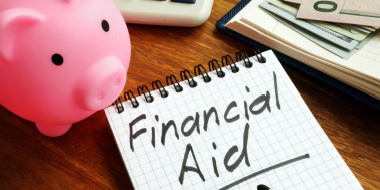 Financial Aid on notepad with piggy bank