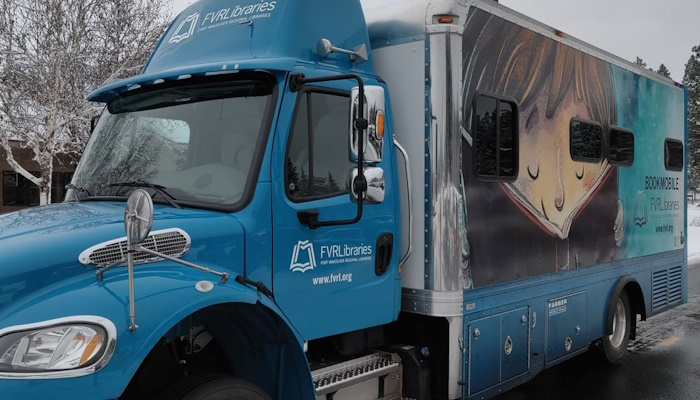 Close up of the bookmobile with frozen, leafless trees around