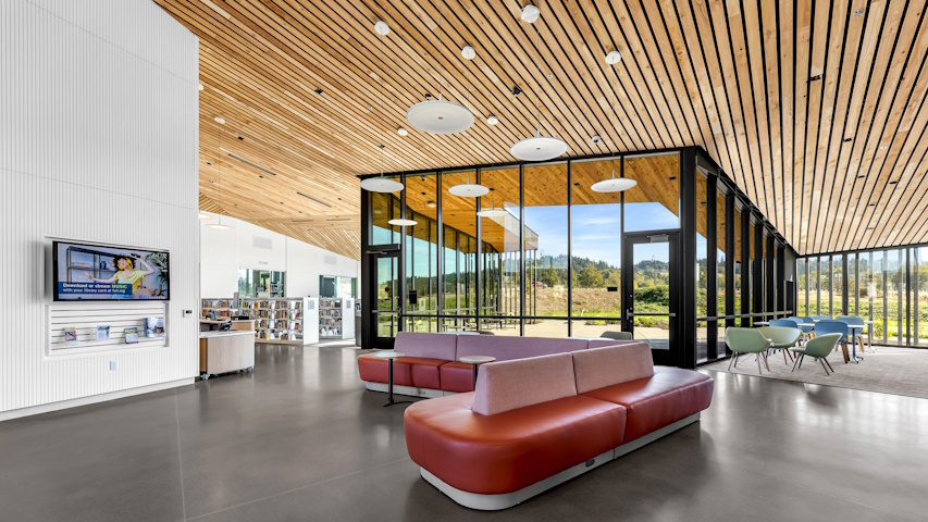 Wide open space featuring low sofas and lots of natural light near the library's entrance