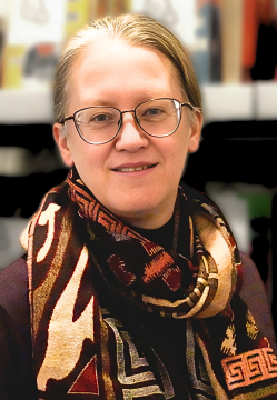 Woman with glasses blonde hair pulled back multi-colored scarf