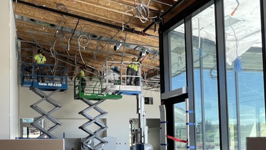 3 workers on lifts working on ducts on high ceiling