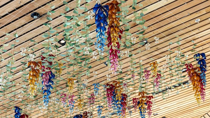 Colorful, dangling artwork made of printed pages called Phonic Bloom